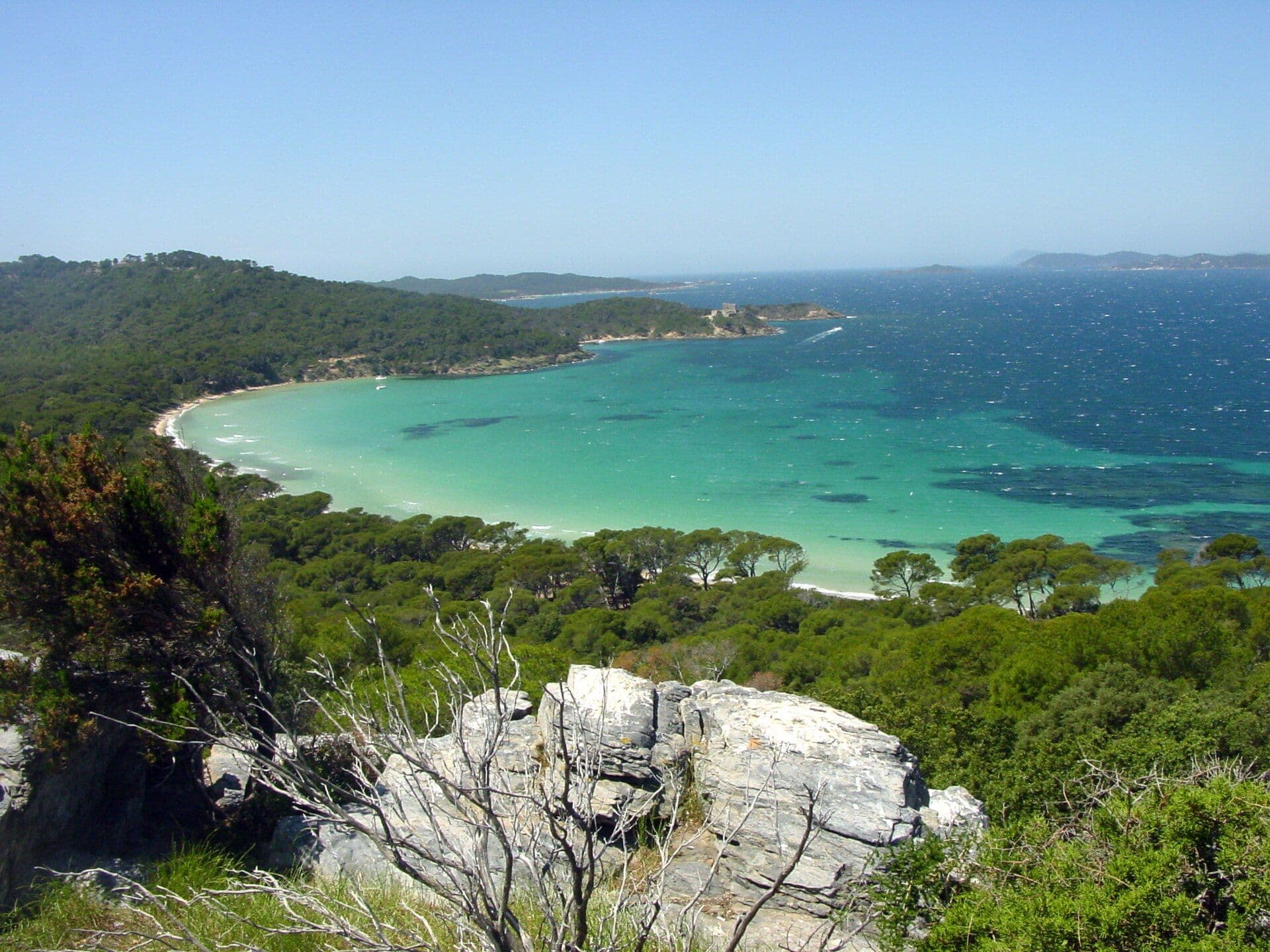 Plage de sable clair et eau turquoise sur l'île de Porquerolles, vue depuis les hauteurs